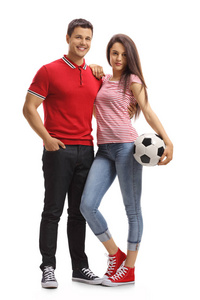 一个年轻夫妇的全长肖像与足球孤立的白色背景