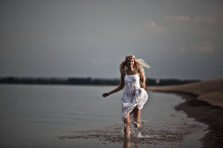 欢快的年轻女孩在水中奔跑溅起水花