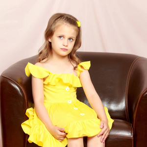 一个小女孩坐在皮椅上