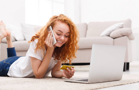 快乐的女孩在线购物与笔记本电脑和电话