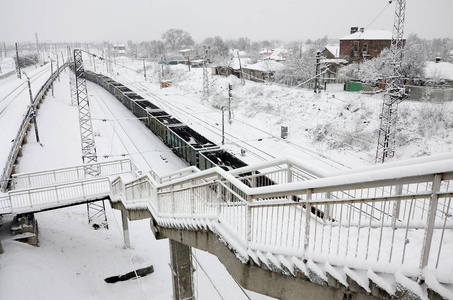 一辆长途货车正沿着铁轨行驶。降雪后冬季的铁路景观