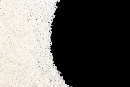 未煮熟的白米在黑色背景下分离。食品概念