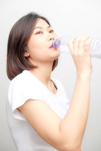 亚洲美女在白色背景下饮用纯净水的健康生活