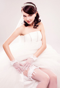 吊袜带新娘修指甲和吊袜带新娘吊袜带蓝丝带放入她的腿伴娘放置吊袜带