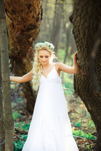 金发女郎白色礼服漫步在夏日森林里
