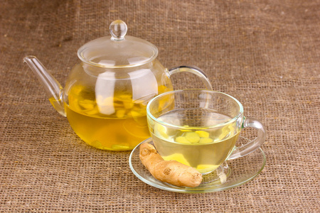 健康生姜茶水壶和麻布上的杯子图片