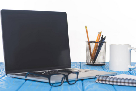 笔记本电脑, 课本, 组织者的眼镜特写镜头与文具和杯子