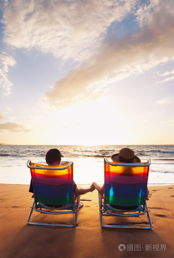 幸福浪漫的情侣在沙滩上享受美丽的夕阳