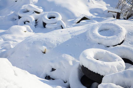 使用和废弃的汽车轮胎躺在路边, 覆盖着厚层的积雪
