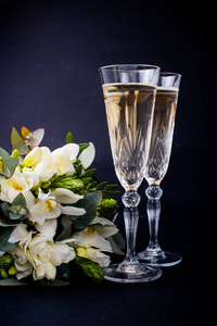 两杯香槟和一束白色花朵