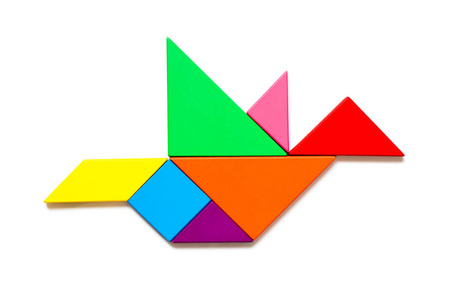 彩色木七巧板拼图在白色背景下的飞鸟形状照片