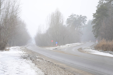 暴风雪中冬季郊区沥青路的十字路口