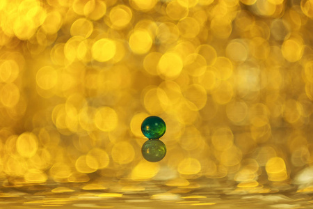 绿色球与反射在黄色散景背景