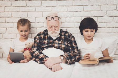 爷爷睡觉, 而孩子使用片剂和阅读
