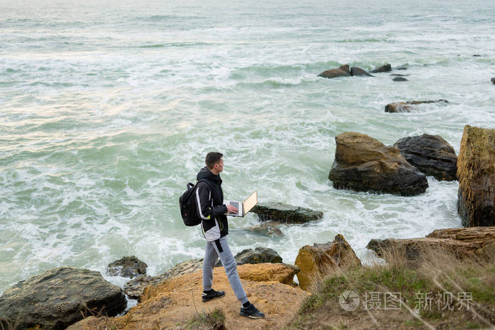 一个男人拿着笔记本, 凝视着远方