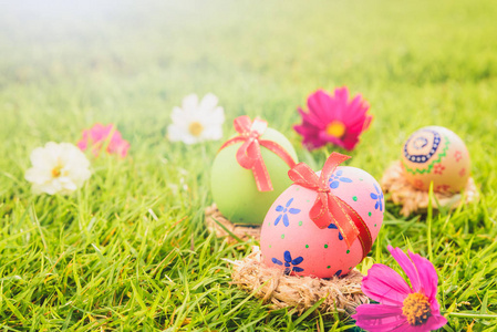 复活节快乐日落背景下, 绿色草地上巢上五颜六色的复活节彩蛋