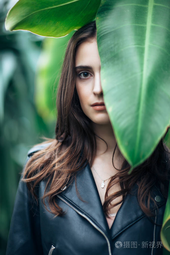 时尚肖像的美丽神秘女人躲在大叶子后面, 特写.