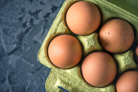 新鲜的农场鸡蛋在绿色托盘, 在美丽的黑暗背景。家居环保产品