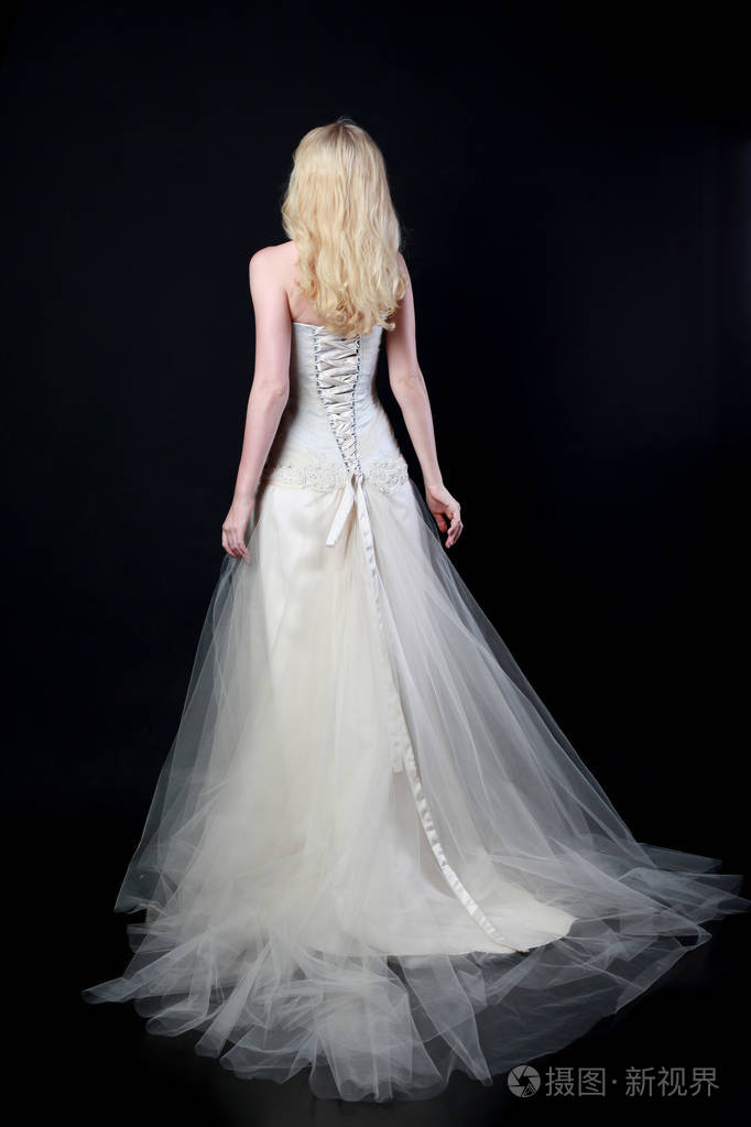 穿白色新娘礼服的模特全长肖像, 黑色背景站立姿势照片-正版商用图片