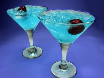 两个酒精蓝色库拉索岛利口酒鸡尾酒与樱桃