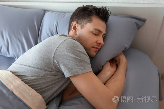 年轻男子在家里的床上睡觉