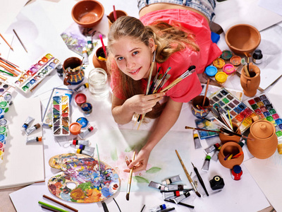 地道的艺术家儿童女孩在地板上画画。顶部视图