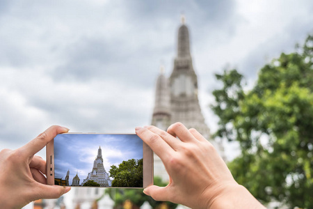 手亚洲妇女游客2030 岁是拍照与智能手机在宝塔阿伦寺它是一个地标和景点泰国曼谷