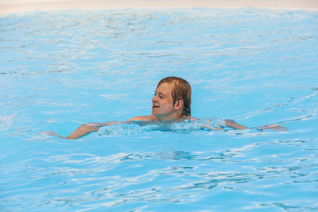 男孩在游泳池中游泳