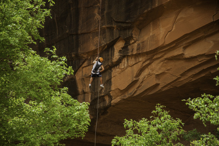 橙色崖下的岩石登山者 rapelling