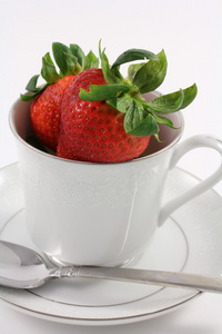 新鲜红草莓里面一个白色的茶杯图片