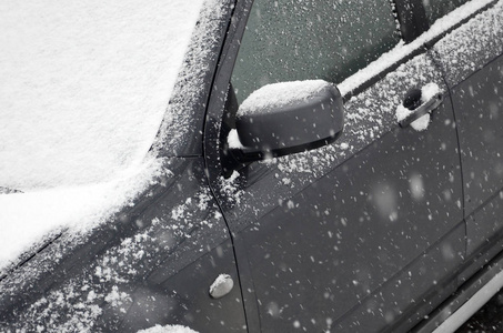 一段大雪后, 汽车碎片下了一层雪。汽车的车身覆盖着白雪。