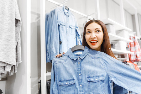 女顾客顾客在时装店里选择衬衫和其他衣服