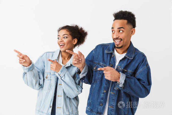 快乐的非洲夫妇在牛仔衬衫指向食指