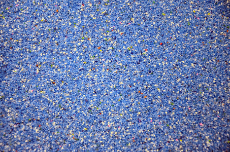 纹理的彩色颗粒砂关闭。蓝色谷物