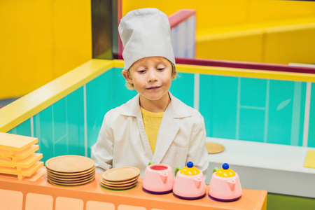 这个男孩玩游戏, 就好像他是个厨师, 或者是孩子厨房里的面包师。