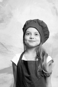 小女孩厨师与笑脸的帽子和围裙