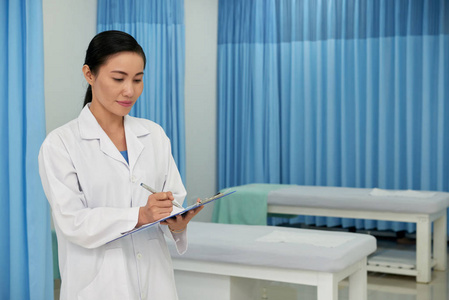 漂亮的越南女医生在文件中记笔记
