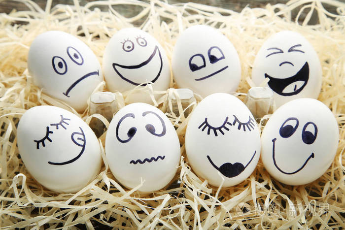 木桌上嵌有滑稽面孔的鸡蛋