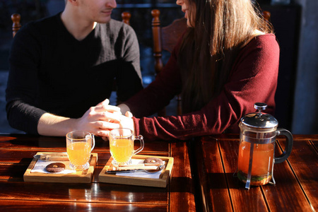 情侣坐在餐桌旁, 在咖啡馆里喝着沙棘汤