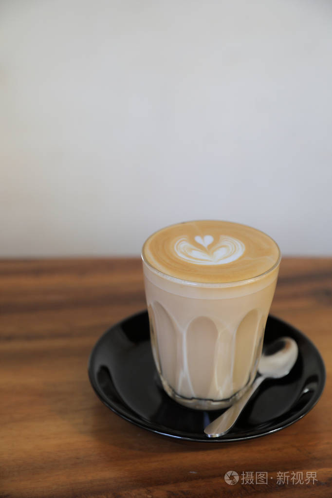 卡布奇诺或拿铁艺术咖啡由牛奶制成的木桌