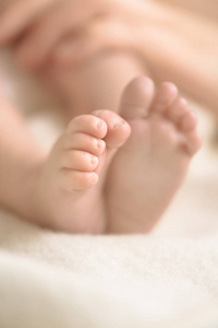 婴儿脚在奶油毯上。妈妈和她的孩子。母性, 家庭, 出生的概念。复制文本的空间