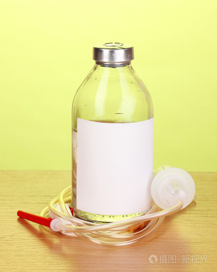 瓶静脉注射抗生素和设置在绿色背景上的木桌上的塑料输液