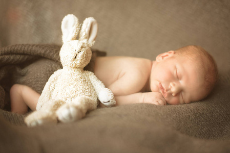 可爱的新生儿睡在灰色背景的玩具。复制文本的空间。母性, 家庭, 出生概念