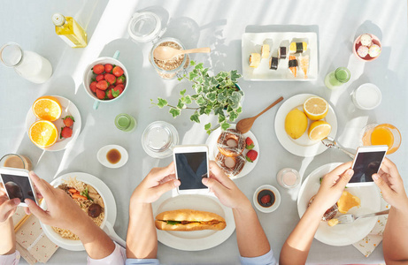 早餐时使用智能手机的人的手