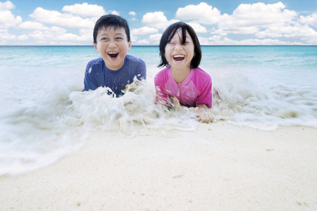 两个小朋友在沙滩上玩浪图片