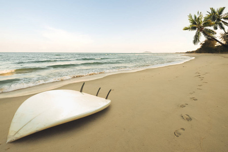 热带海滩冲浪板在夏天日出。海滨海景夏日沙滩, 蓝天背景