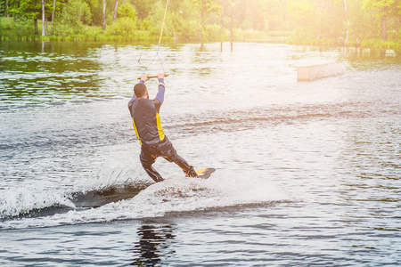 wakeboarder 骑在河上的木板上阳光明媚的夏日