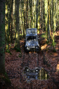 肮脏的越野汽车与秋天森林在背景上