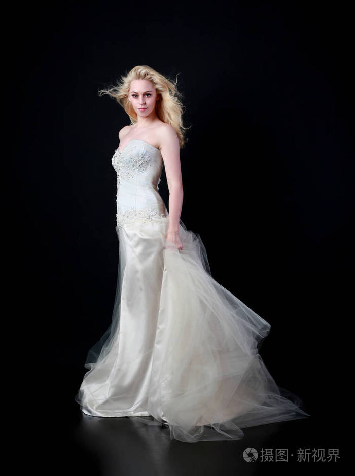 穿白色新娘礼服的模特全长肖像, 黑色背景站立姿势照片-正版商用图片
