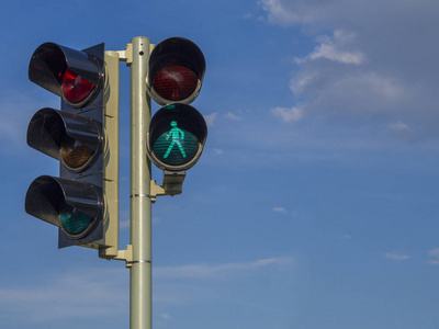 蓝天背景下交通信号灯穿过马路在红绿灯的禁止信号下横穿马路一个女人